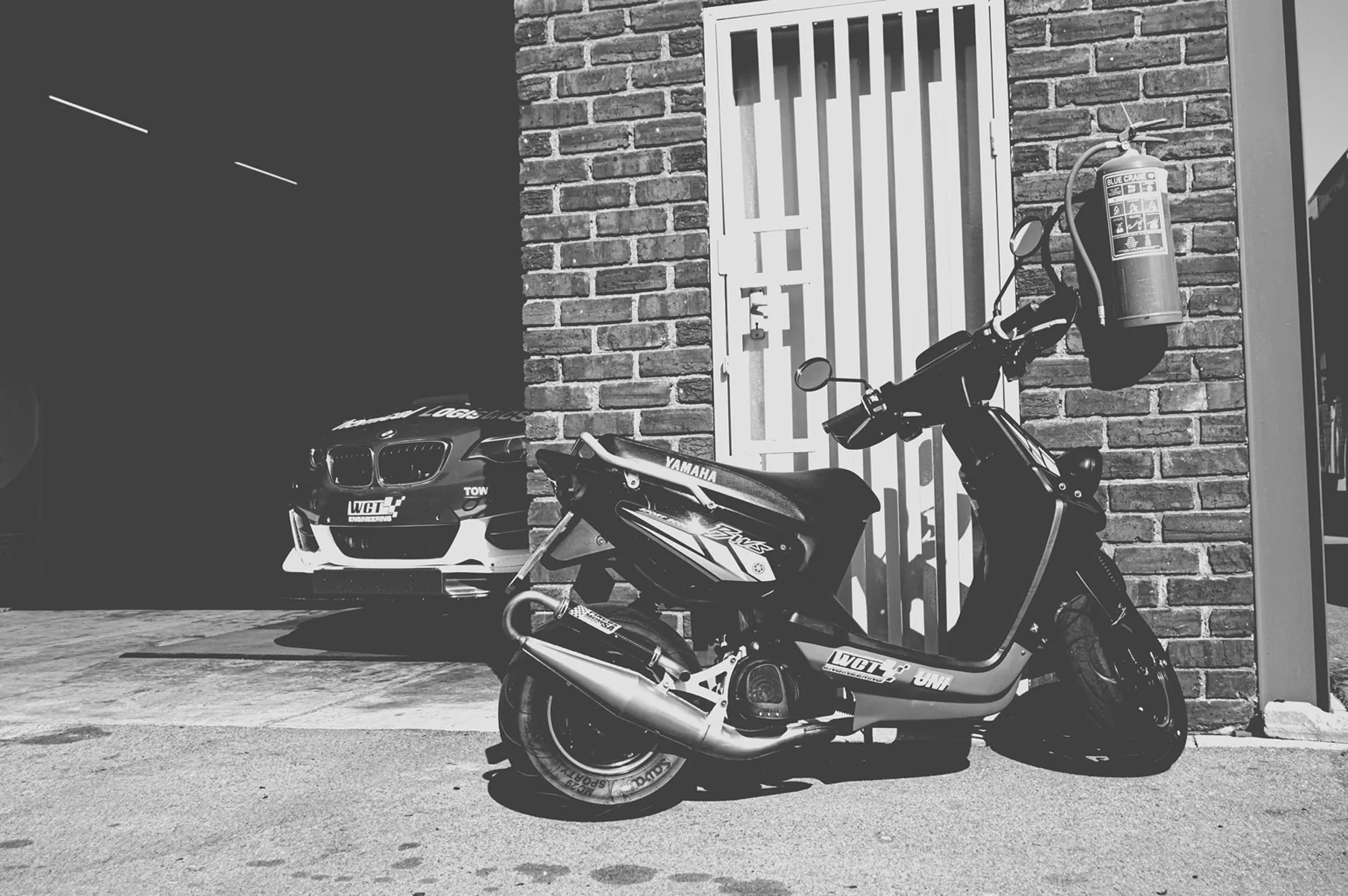 2019-07-27 - Zwartkops Raceway - Scooter parked next to garage with race car 