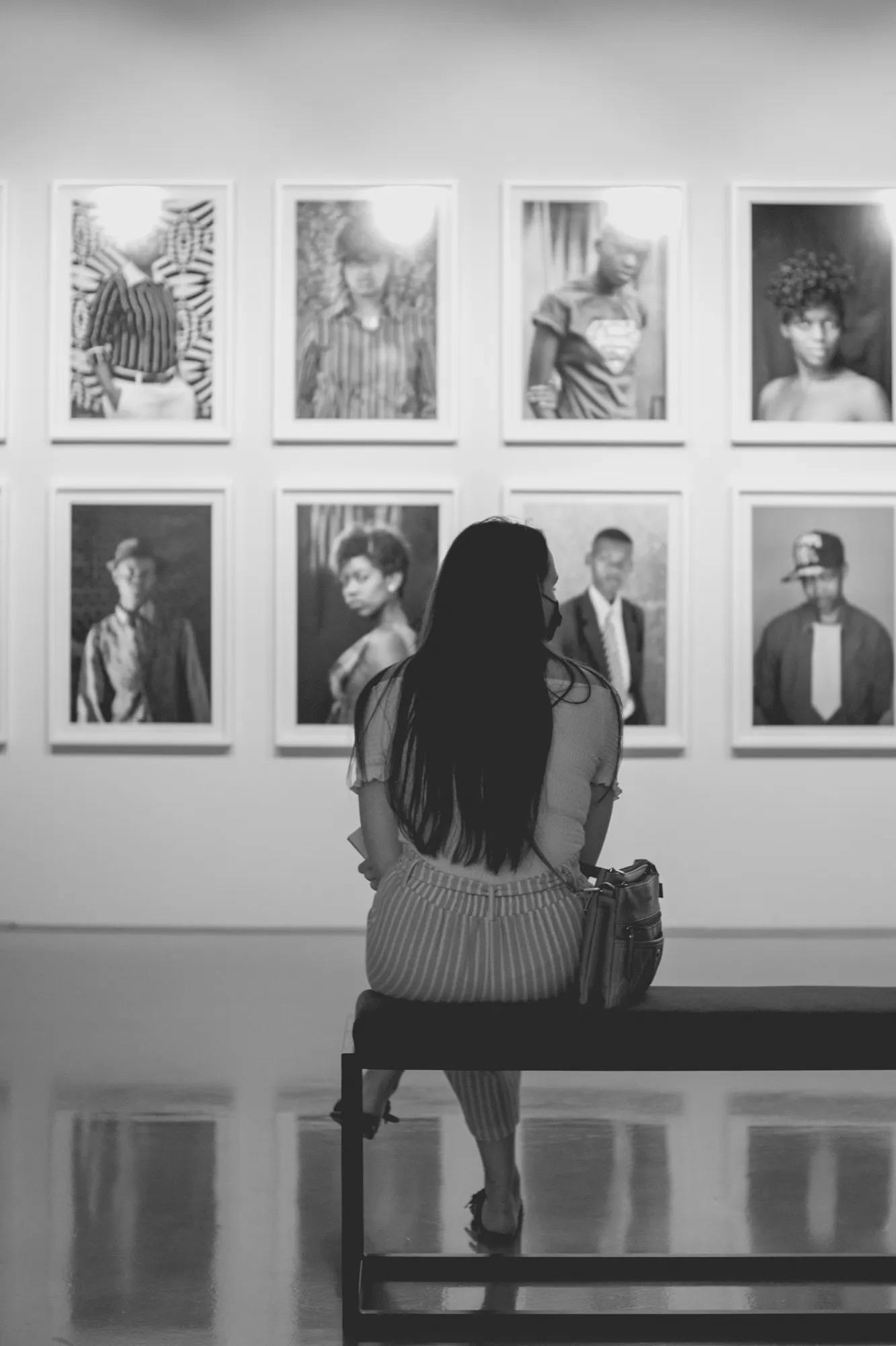 2022-02-16 - Cape Town - Person sits on bench looking at photos on the wall