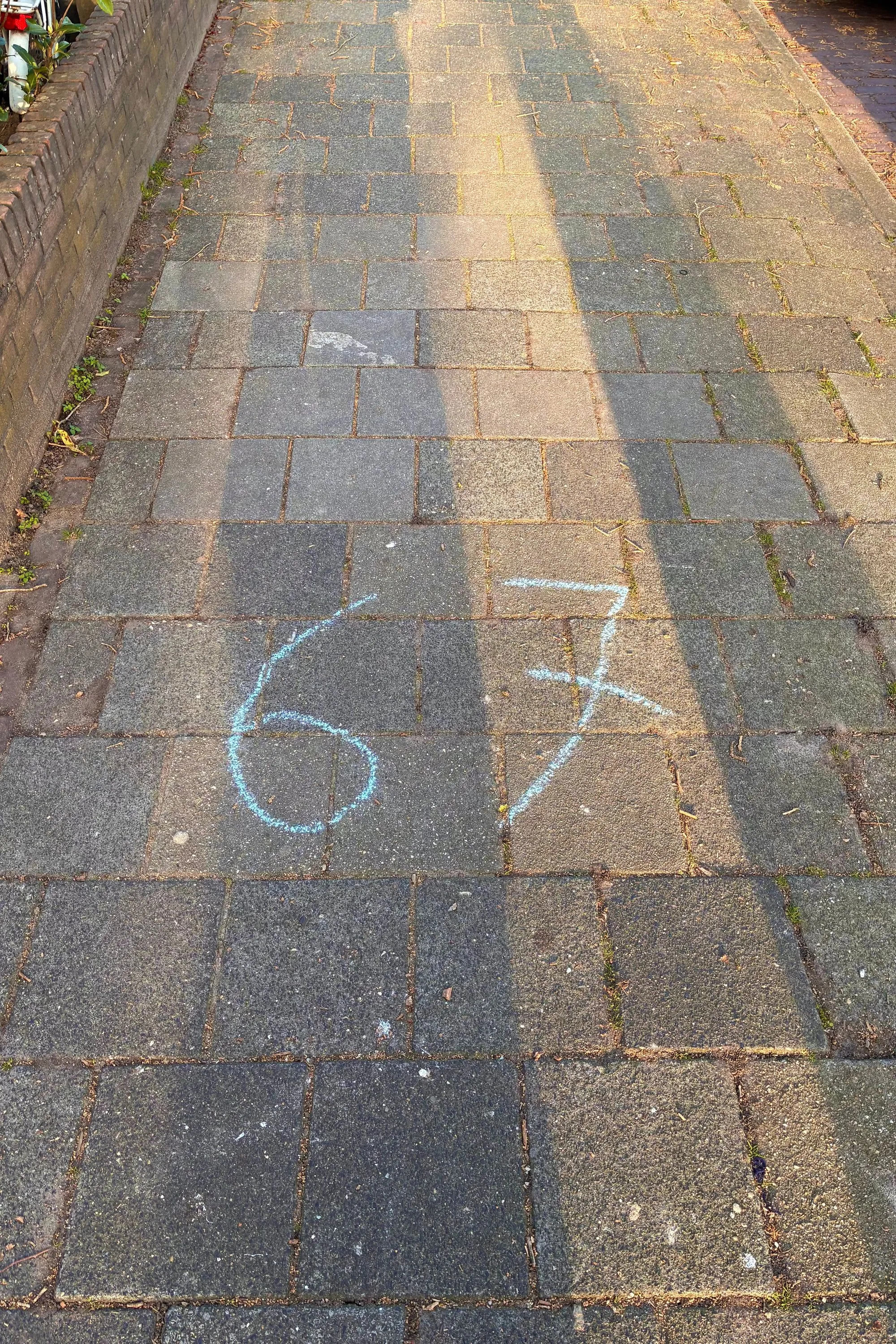 2026-03-08 - Number 67 in blue chalk on the sidewalk