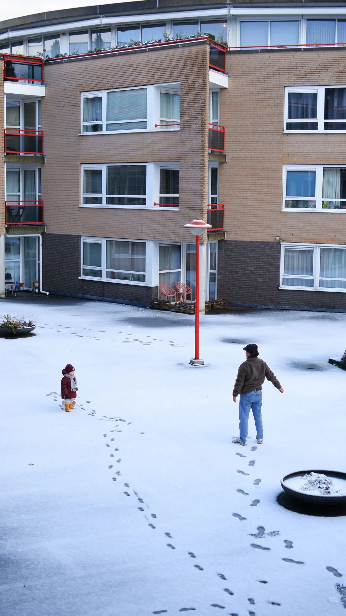 Parent and child standing in the snow