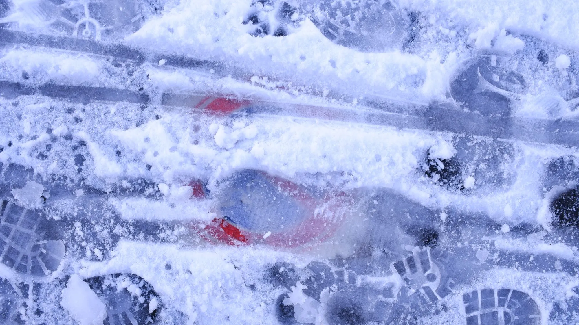 Sign frozen behind ice on the ground