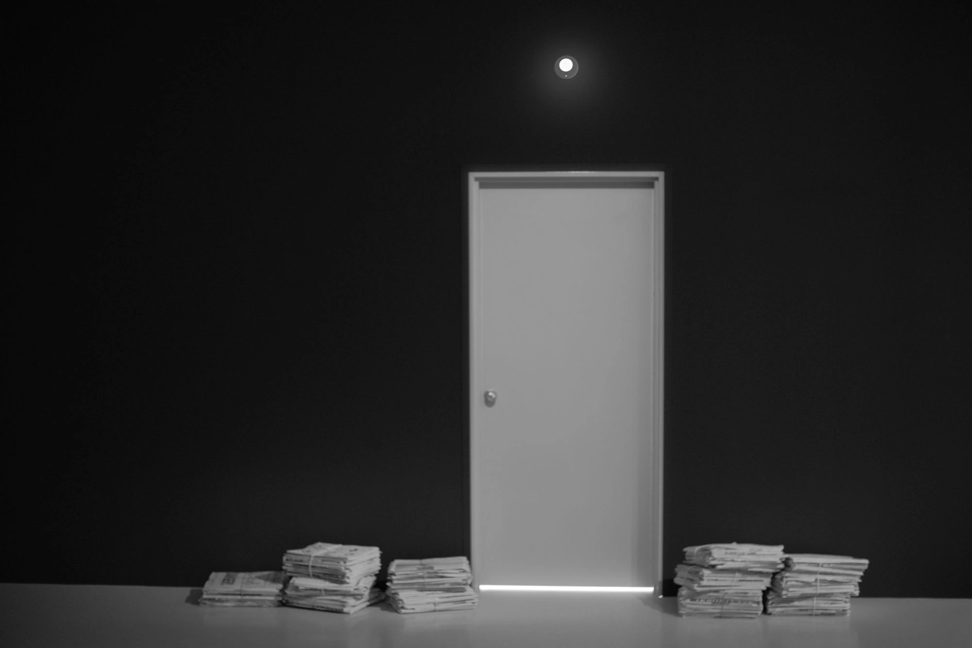 Door with stacks of newspaper beside it
