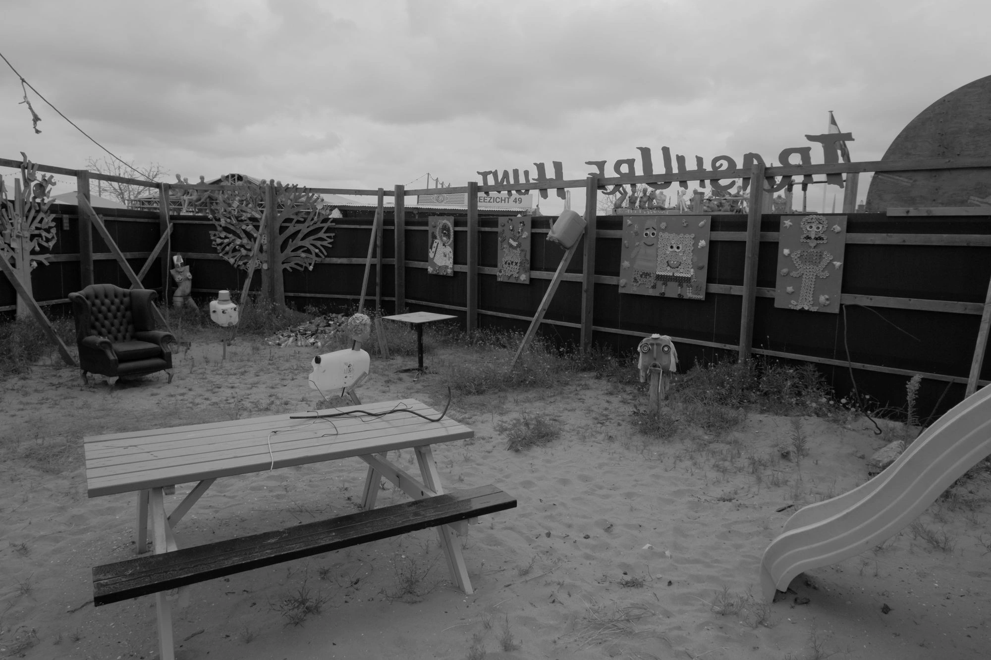 2026-07-18 - xt15-45 - bw - NL - Scheveningen - Abandoned park on beach with weird sculptures around it