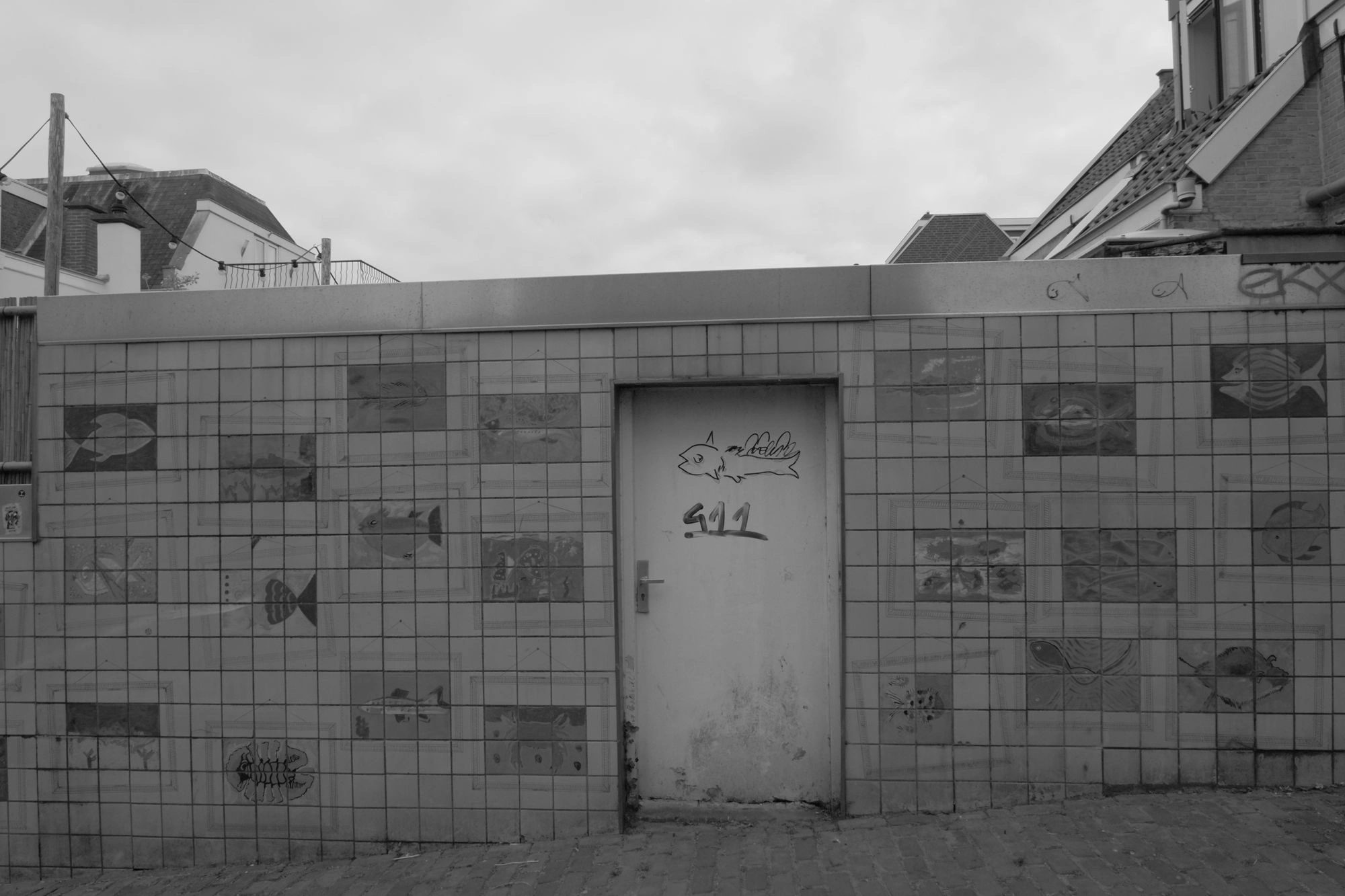 2026-07-18 - xt15-45 - bw - NL - Scheveningen - Door surrounded by paintings of fish