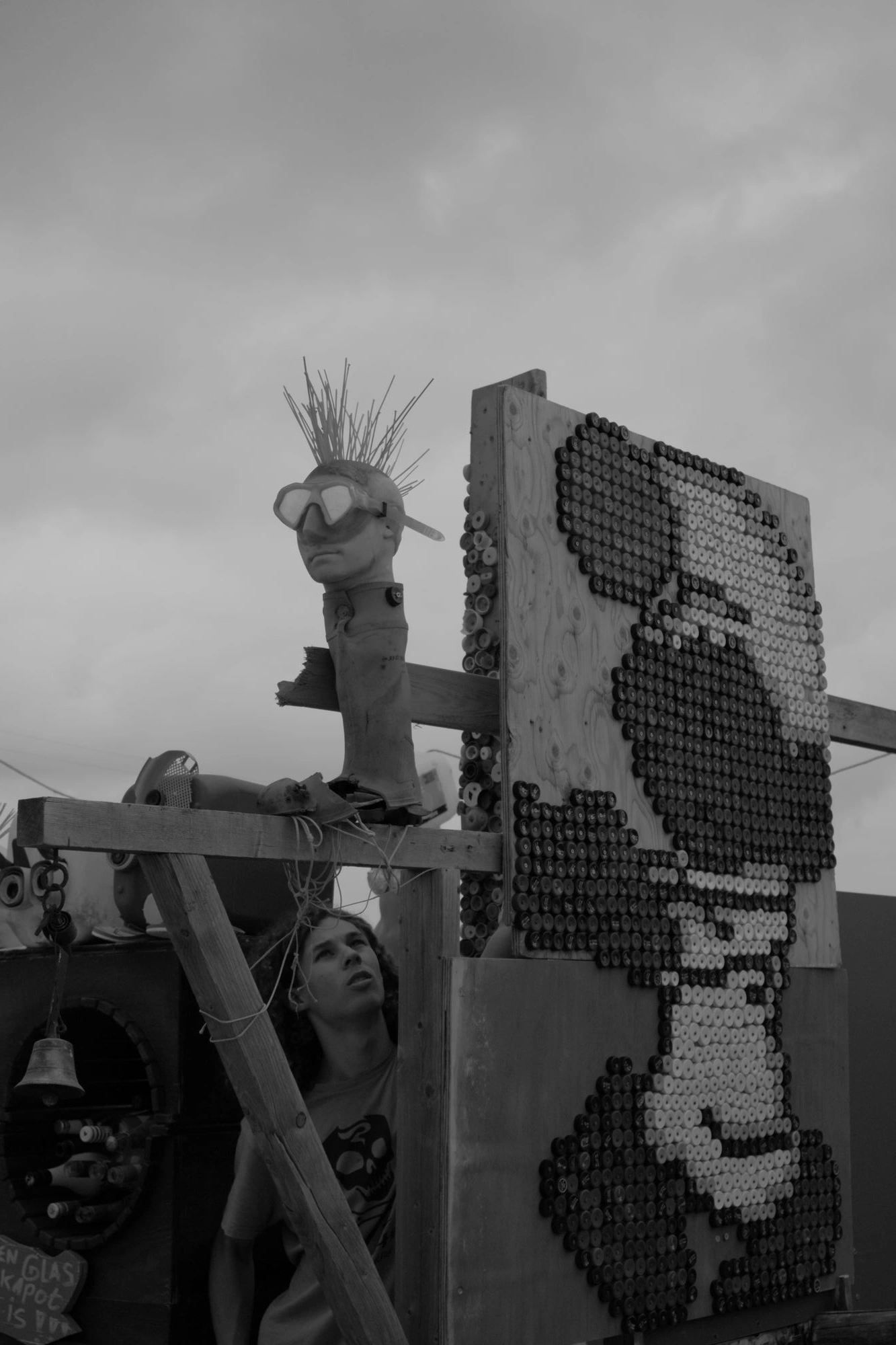 2026-07-18 - xt15-45 - bw - NL - Scheveningen - Person mounting sculpture of head