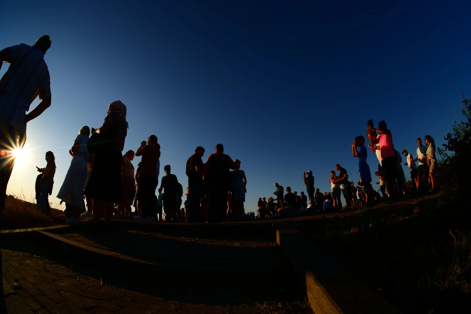 People holding up phones watching the sun