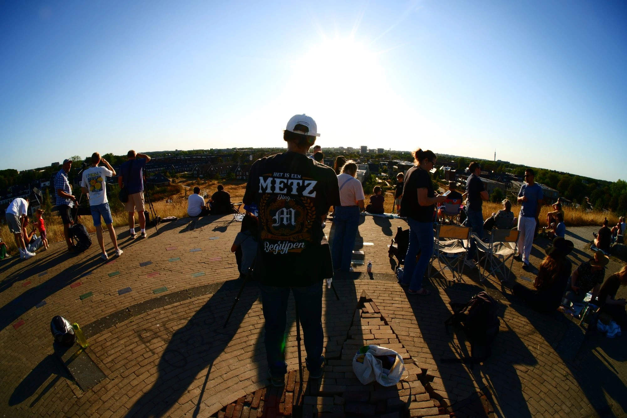 Person with tripod pointing at sun