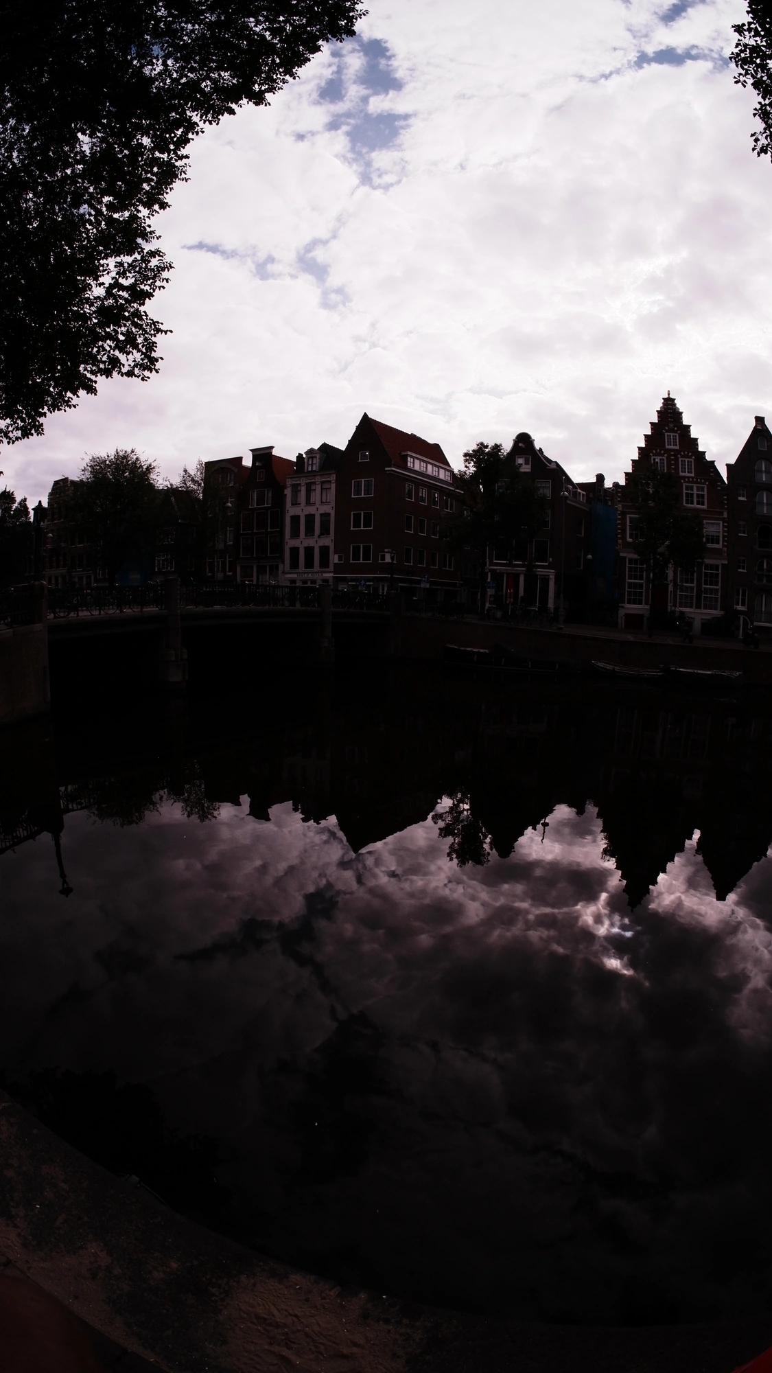 Moody picture of canal with old dutch buildings reflected by the water