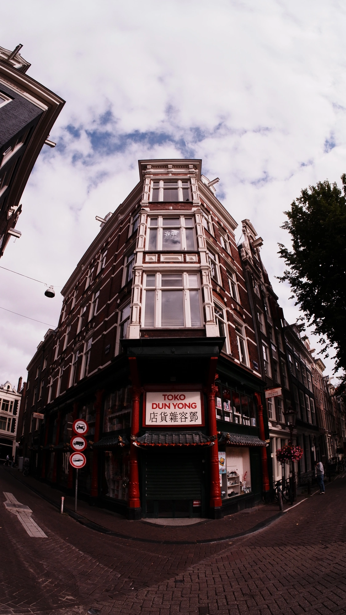 Red facebrick building with shop reading "Toko dun yong"