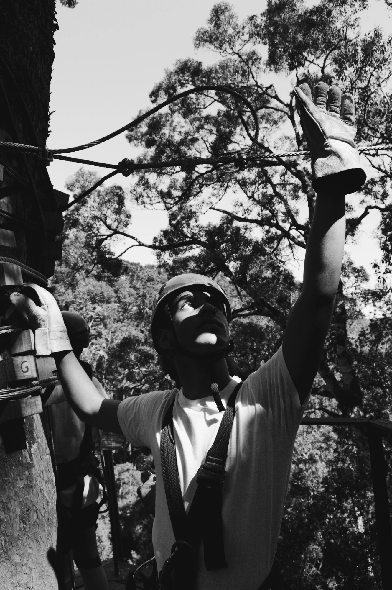 Person with climbing gear standing in the trees