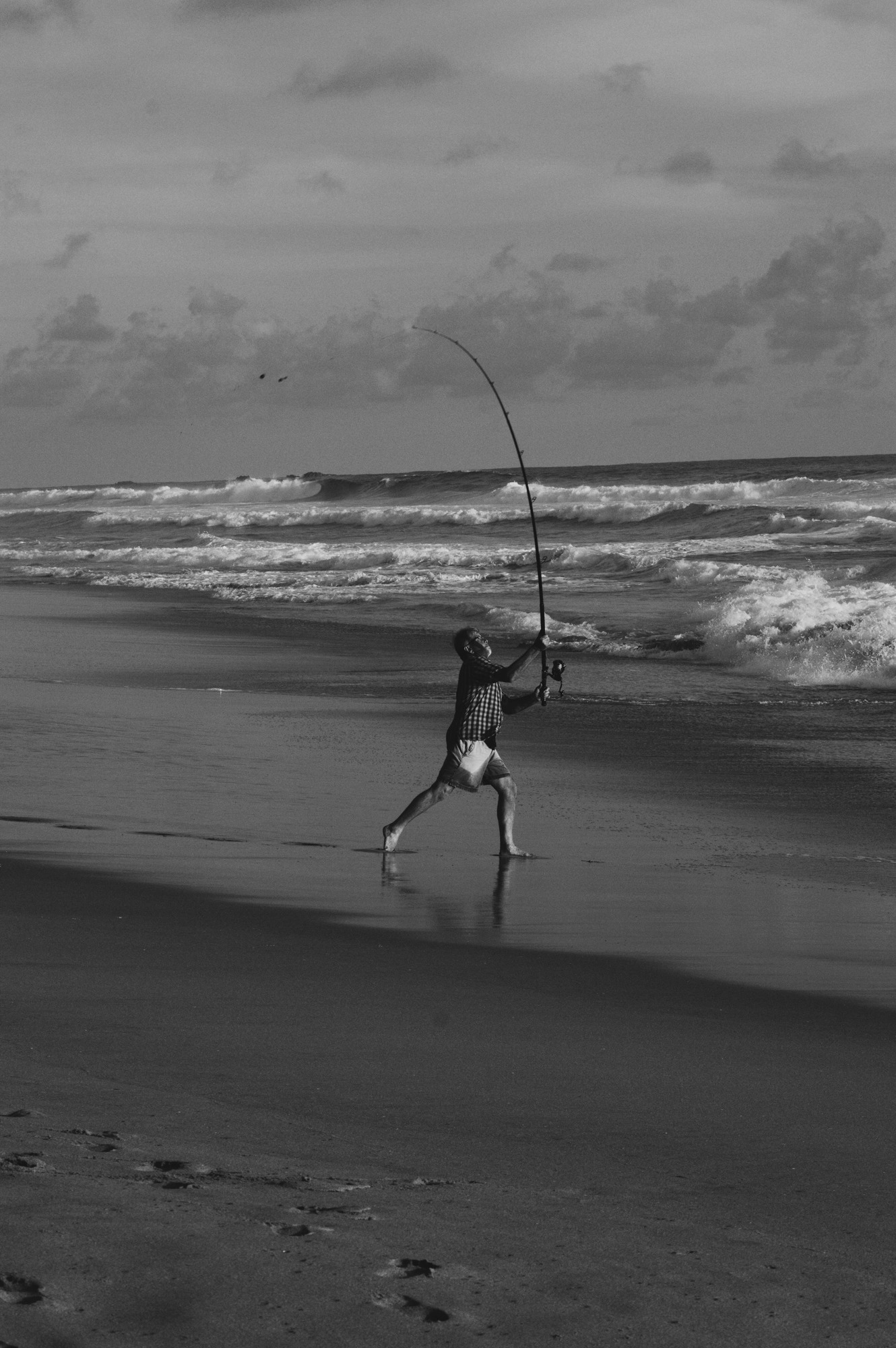 Fisherman casting a line from the beack