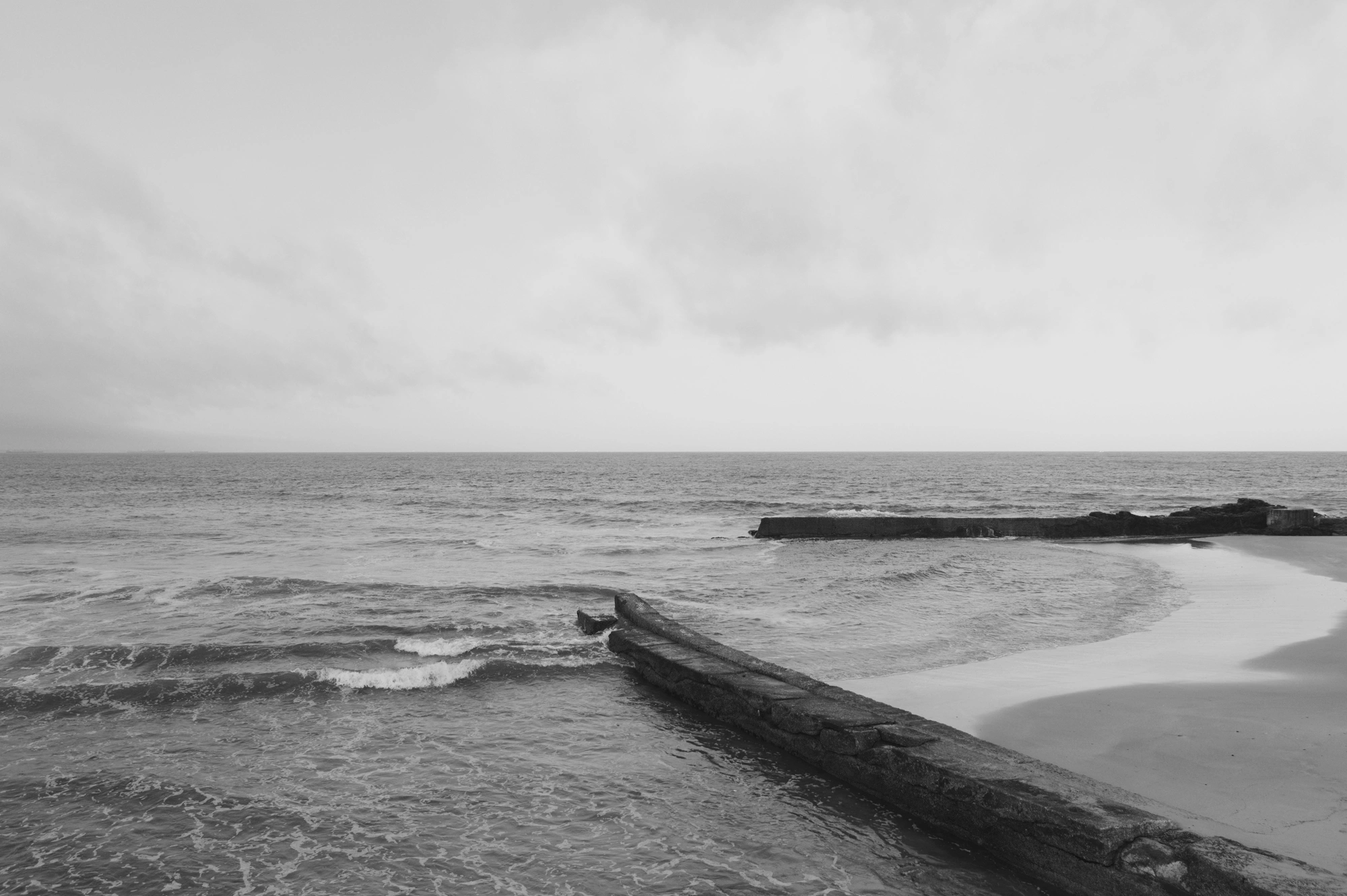 Walls on the beach leading into the ocean