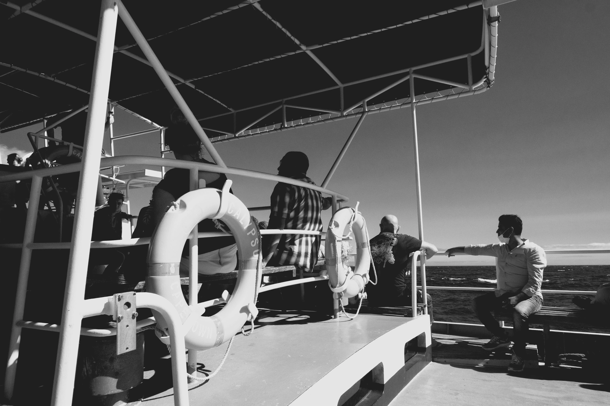 2022-02-13 - xt15-45 - bw - ZA - Cape Town - People on boat looking out into the ocean
