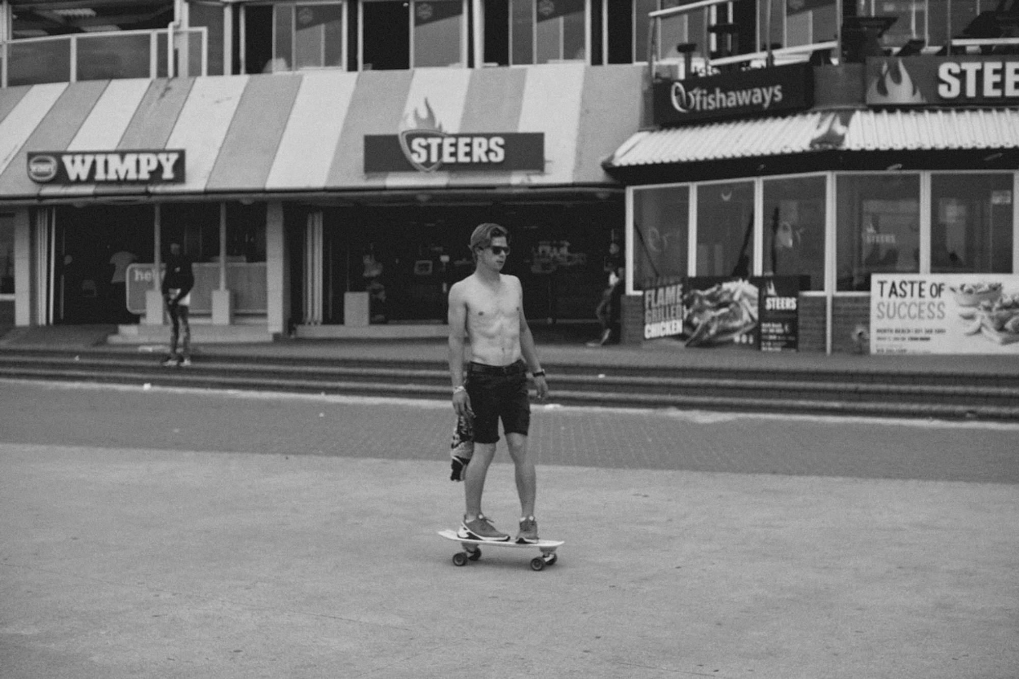 2022-09-18 - xt35 - bw - ZA - Durban - Man skates on beach