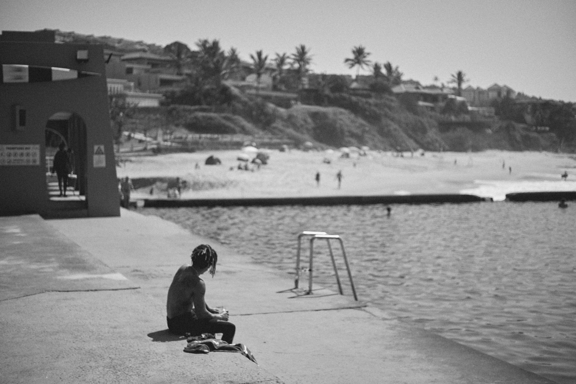 2022-09-22 - xt35 - bw - ZA - Durban - Person sitting beside tidal pool