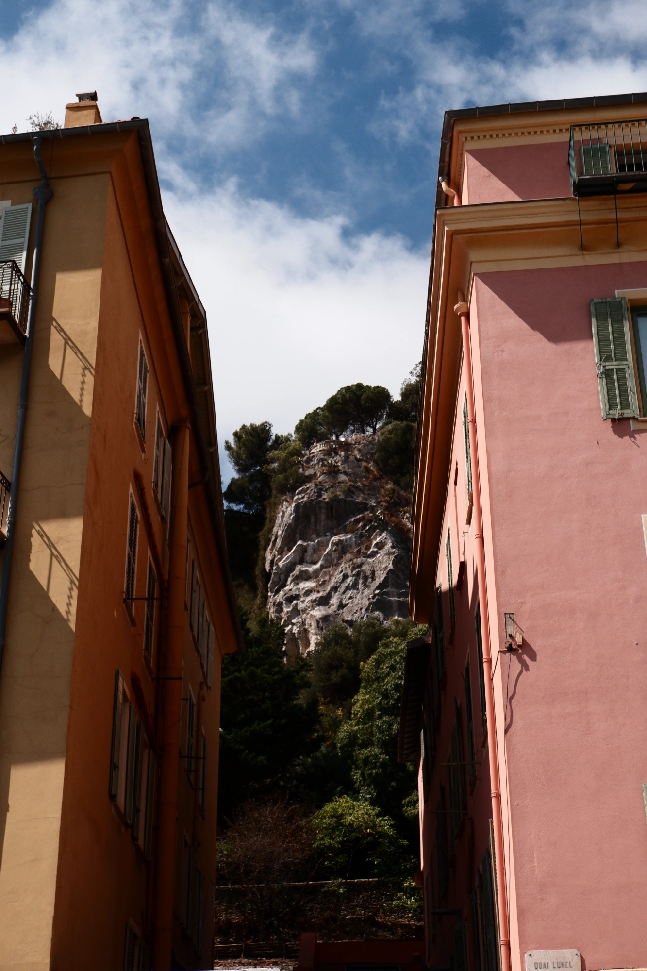 Mountain between pink and orange buildings
