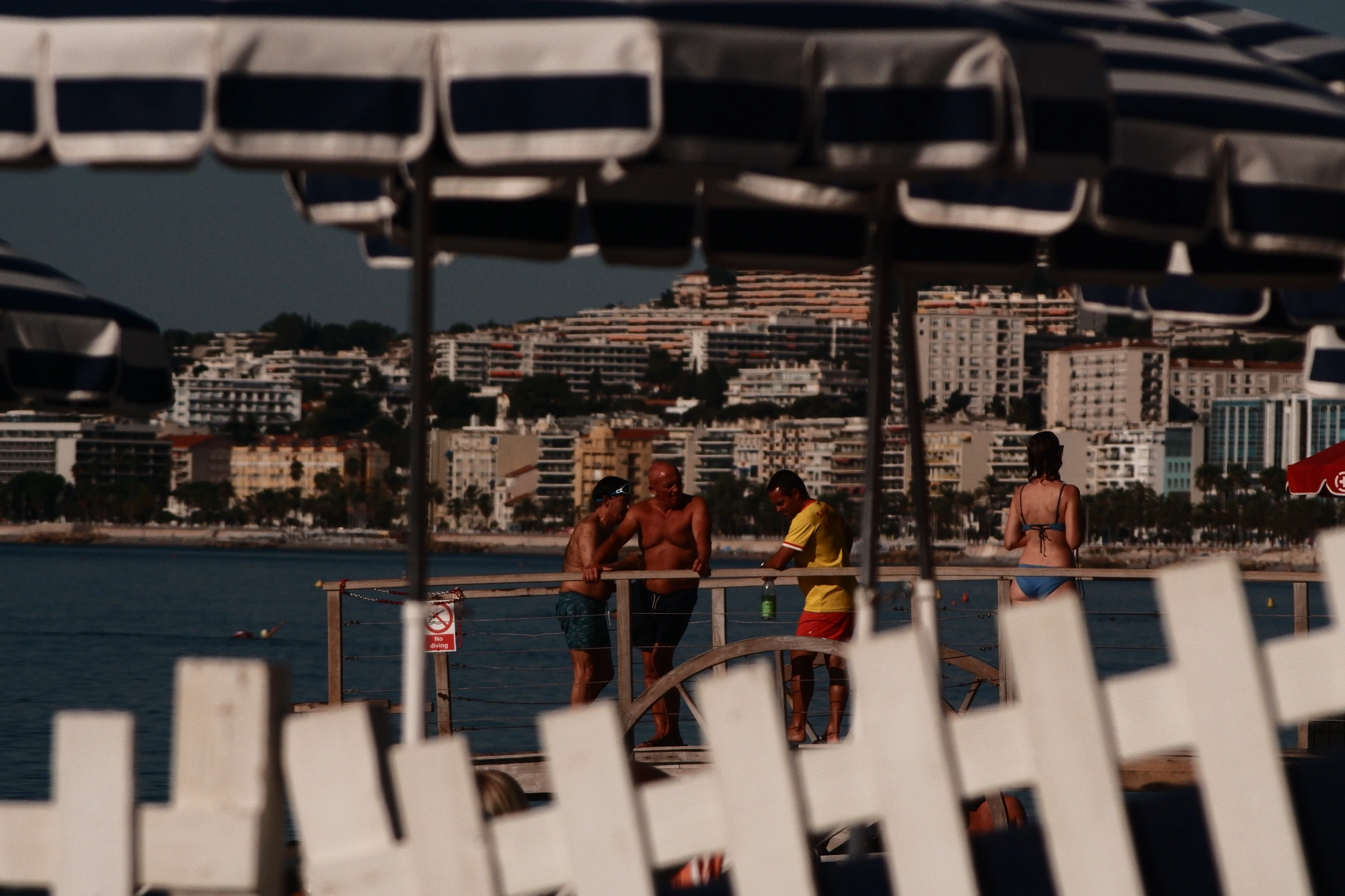 People standing at beach between umbrellas
