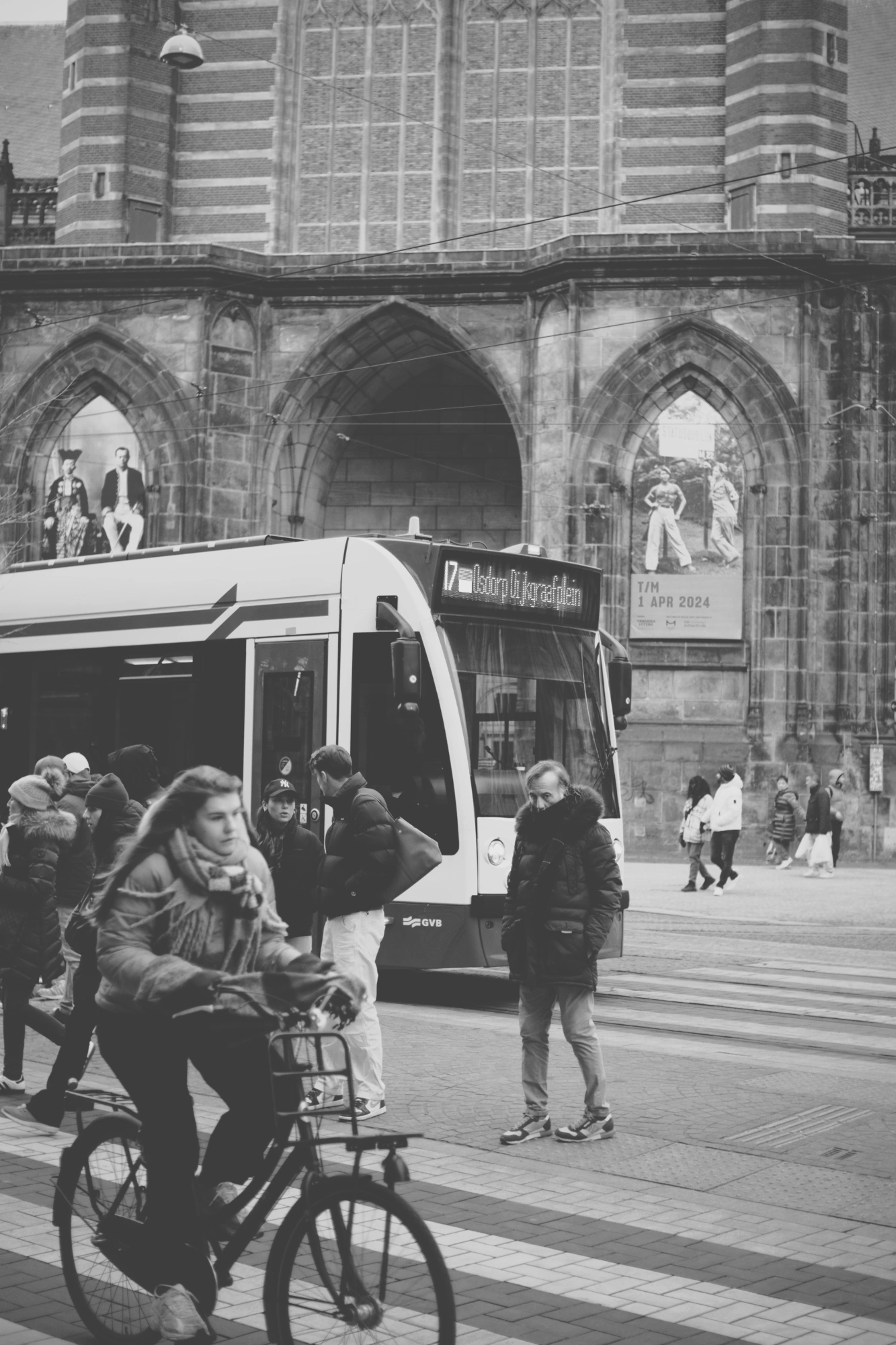 2024-01-21 - xt35 - bw - NL - Person crossing road in front of tram