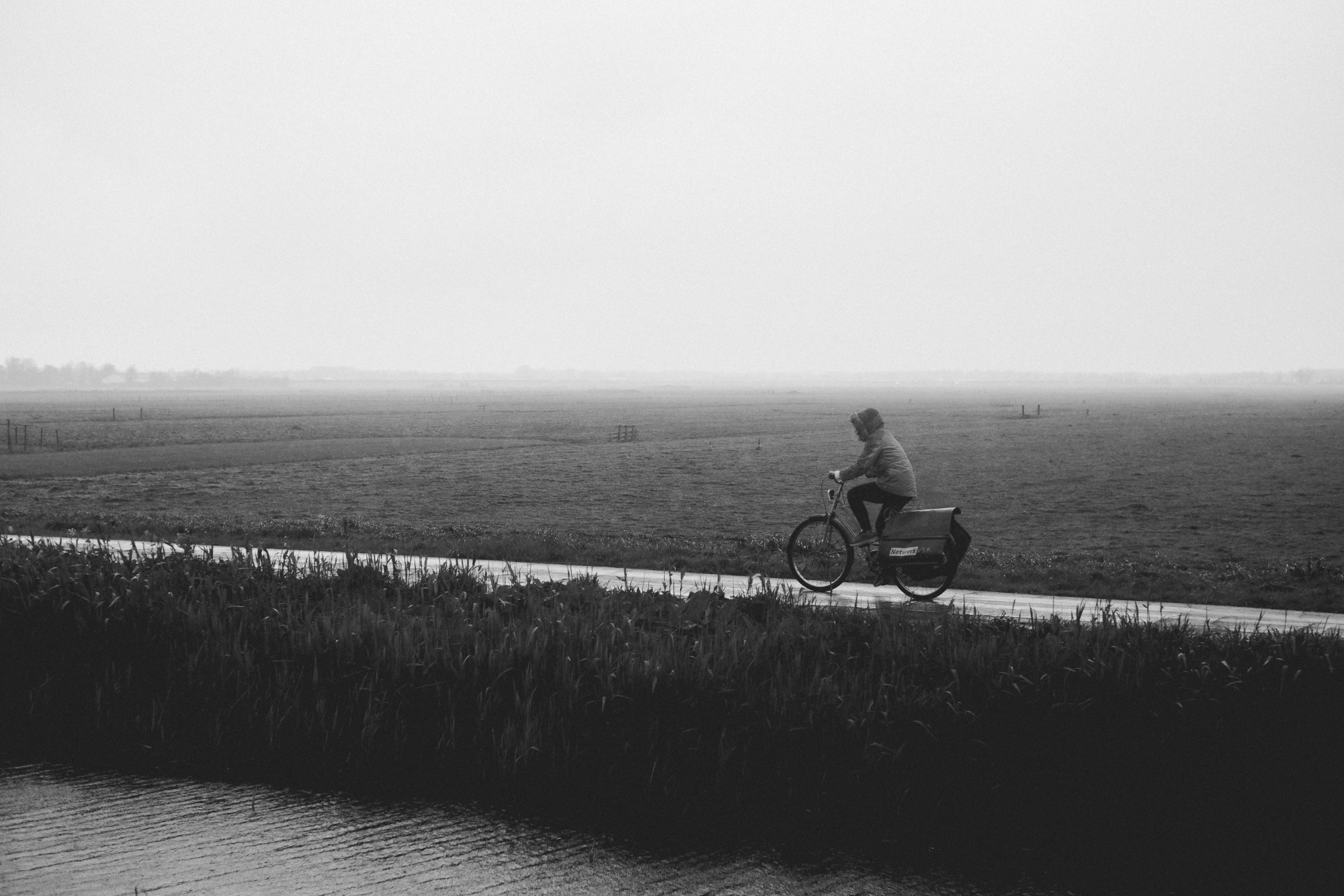 2024-04-19 - xt35 - bw - NL - Person cycling in the rain