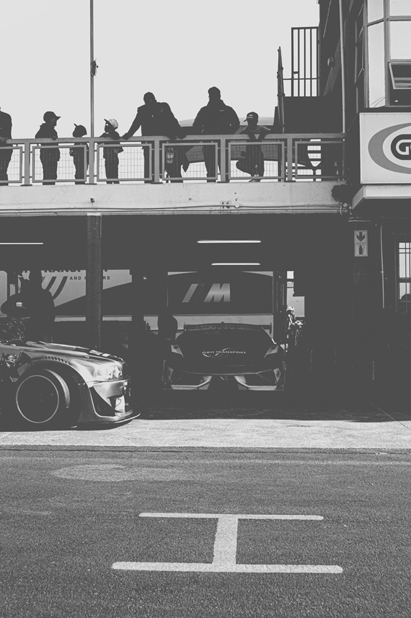 2019-07-27 - n18-55 - bw - ZA - Zwartkops Raceway - Race cars in garage beside track