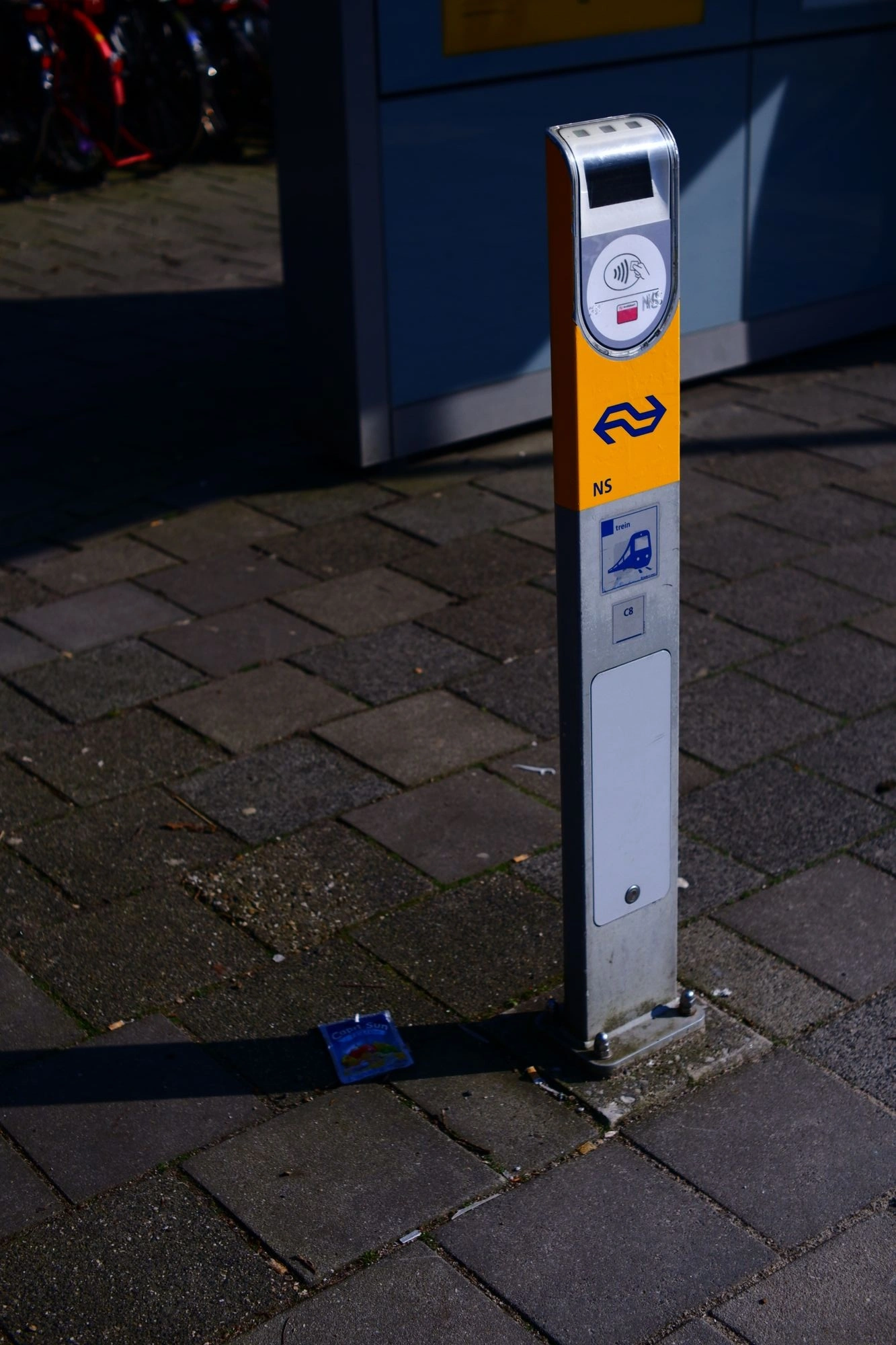 2026-03-15 - NS train check-in machine with Capri Sun on floor next to it.J
