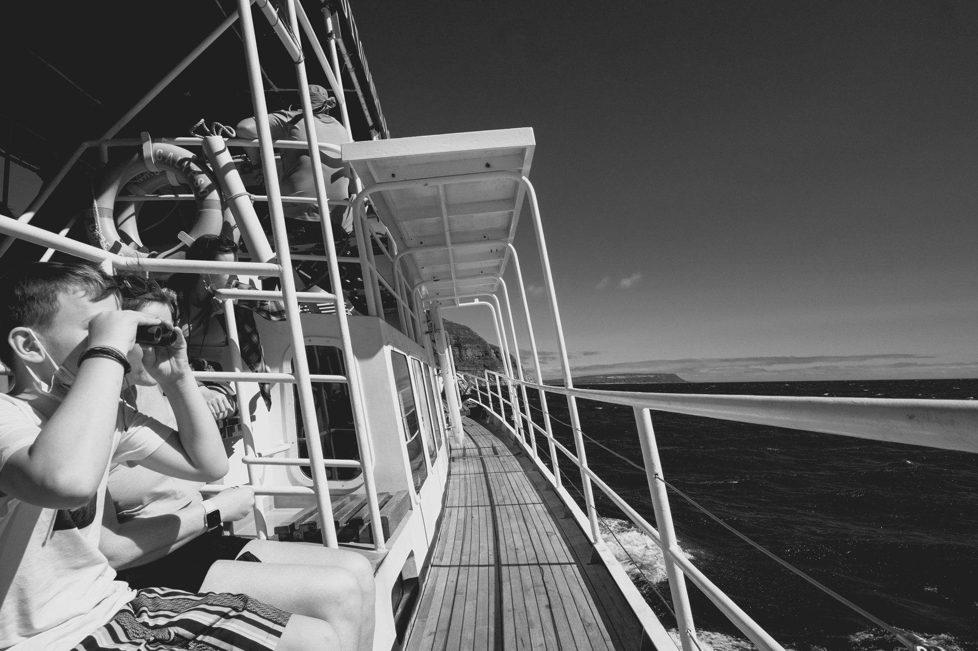 2022-02-13 - Cape Town - People looking over the railing of a boat into the ocean.j