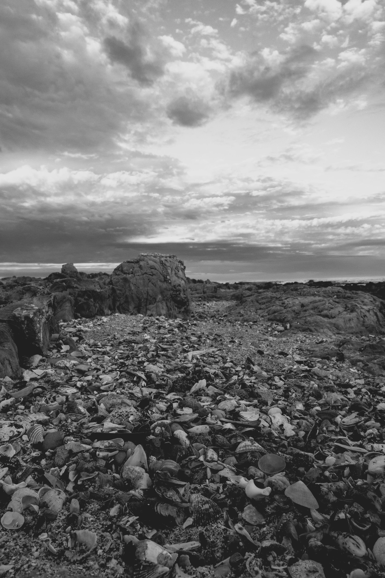 2022-02-13 - Cape Town - Rocks and the ocean under a partly cloudy sunrise.j