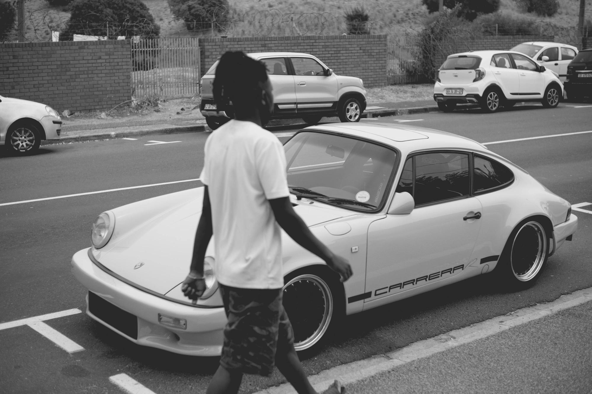2022-02-18 - Cape Town - Man walking beside porsche.j