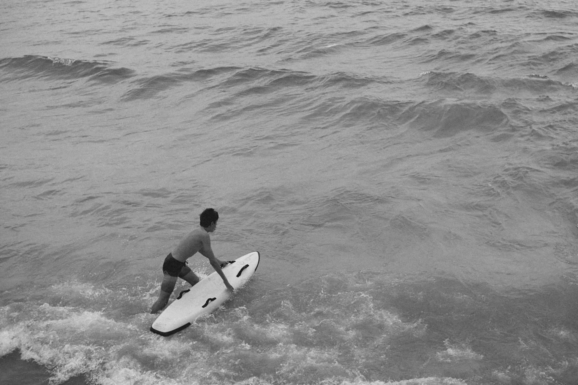 2022-09-18 - Durban -  Boy swimming into ocean with surfboard.j