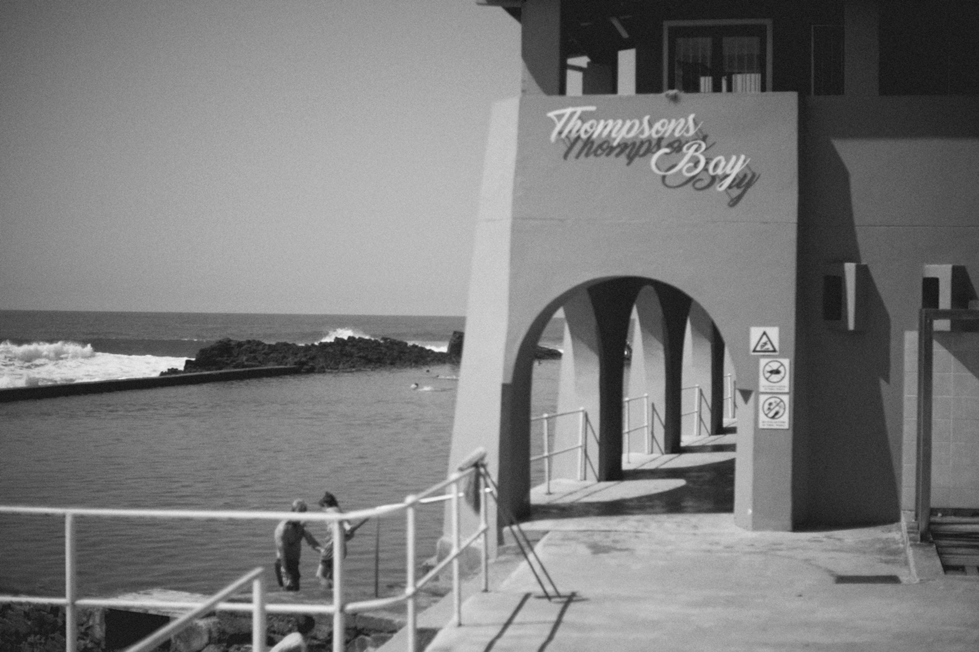 2022-09-22 - Durban -  Pathway alongside a tidal pool with sign that reads 'Thompsons Pier'.j